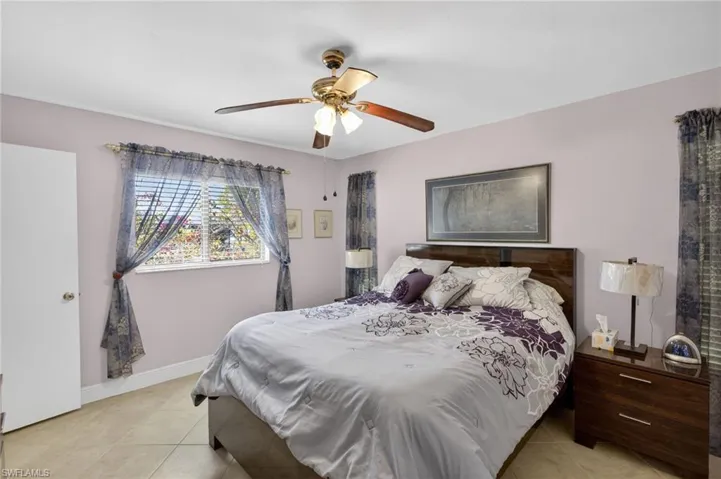 Bedroom with ceiling fan and light tile patterned floors