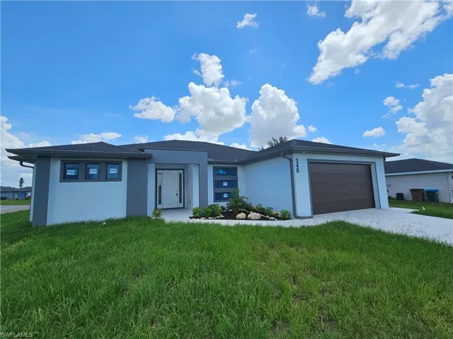 Prairie-style home with a garage and a front lawn