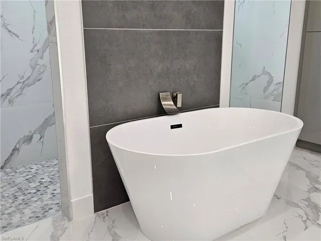 Bathroom featuring a tub to relax in and tile patterned floors