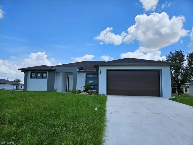 View of front of home with a garage and a front yard