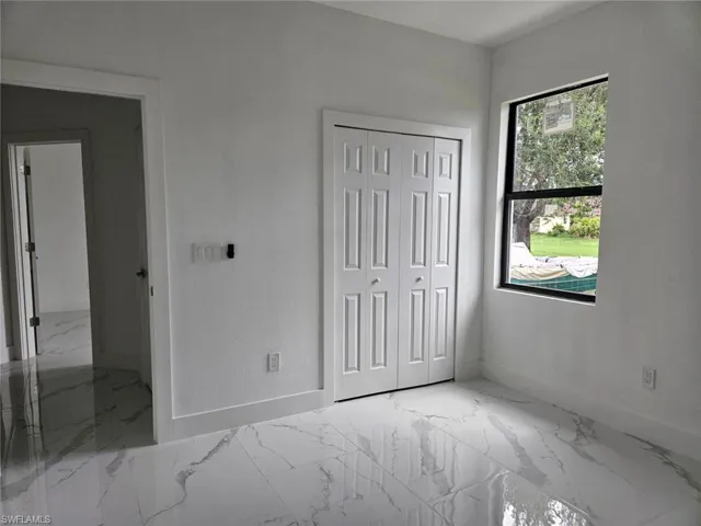 Unfurnished bedroom featuring tile patterned flooring and a closet