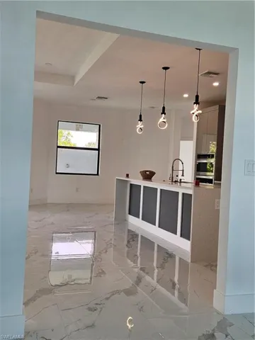 Kitchen featuring light tile patterned flooring, sink, and decorative light fixtures