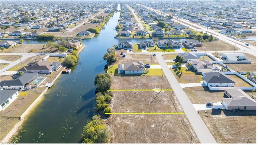 Aerial view of residential area featuring property parcel outlined and a large body of water