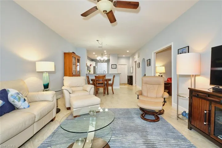 Living room featuring a ceiling fan and a chandelier