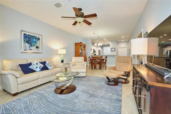 Living room with a ceiling fan, a chandelier, light tile patterned floors, and recessed lighting