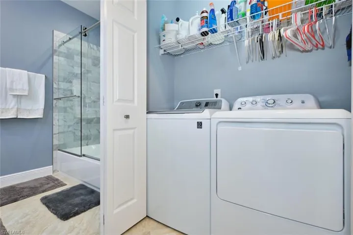 Laundry area featuring washing machine and dryer and baseboards