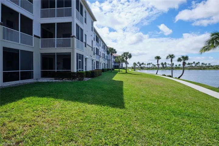 Surrounding community with a sunroom, a yard, and a water view