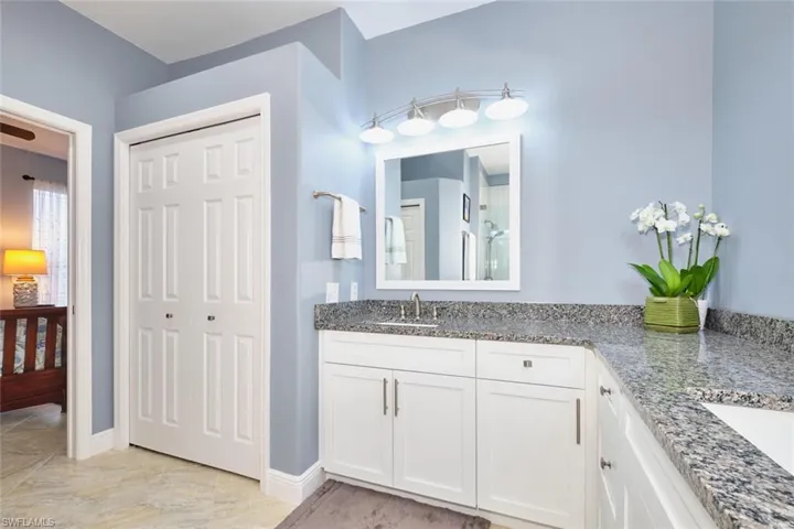 Full bath featuring double vanity and a closet