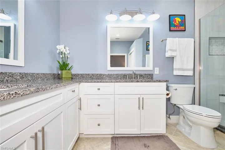 Full bathroom featuring double vanity and a shower with shower door
