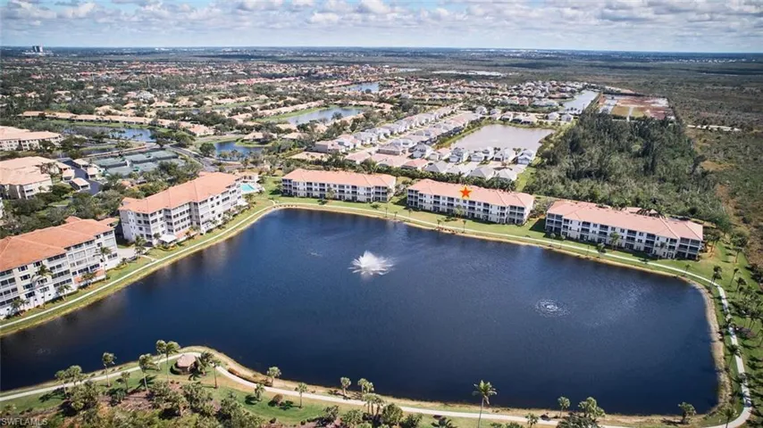 Aerial view of property and surrounding area featuring a large body of water and apartment complex / building