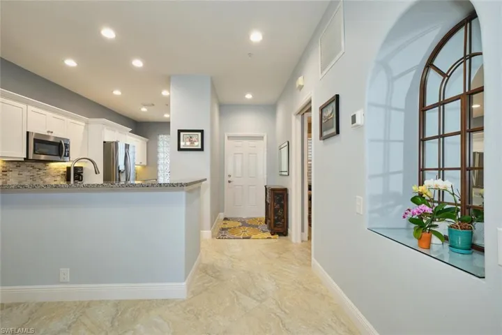 Kitchen featuring white cabinets, stainless steel appliances, dark stone countertops, recessed lighting, and backsplash