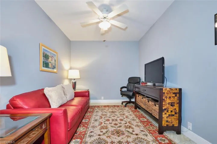 Living area featuring baseboards and ceiling fan
