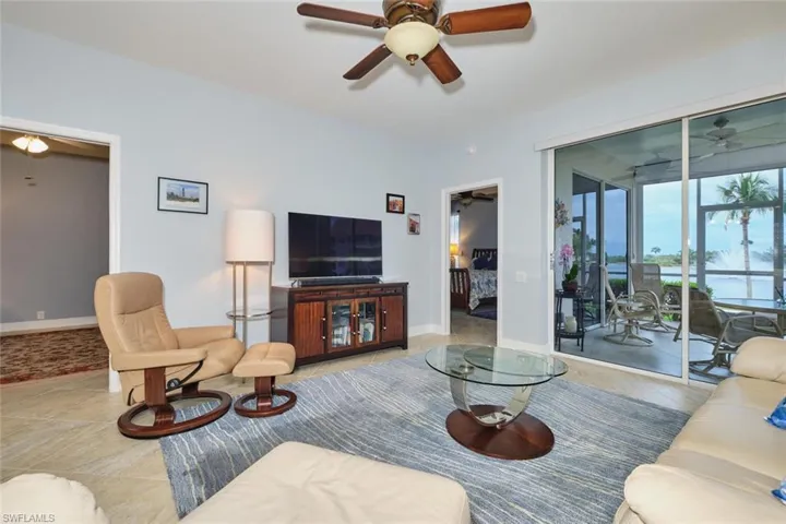Tiled living room featuring a ceiling fan and baseboards