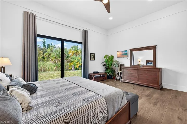 Bedroom featuring wood finished floors, access to outside, and a ceiling fan