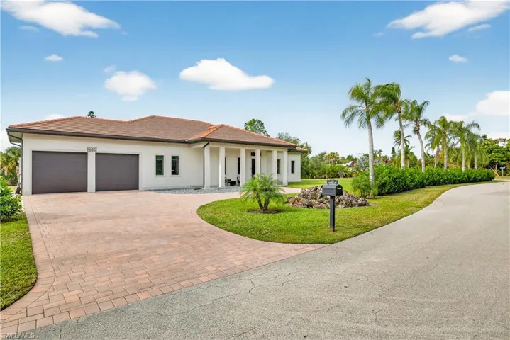 Mediterranean / spanish-style house with a front yard, decorative driveway, a garage, stucco siding, and a porch