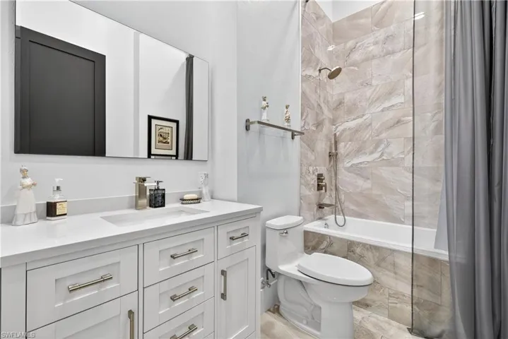 Full bathroom with tiled shower / bath and vanity