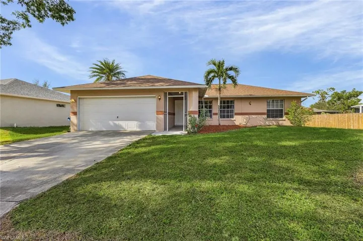 Ranch-style house with a front yard and a garage