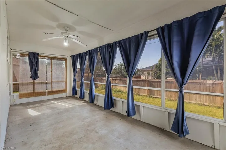 Unfurnished sunroom with ceiling fan and plenty of natural light