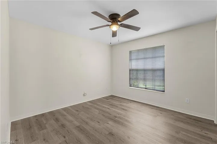 Empty room with ceiling fan and hardwood / wood-style flooring
