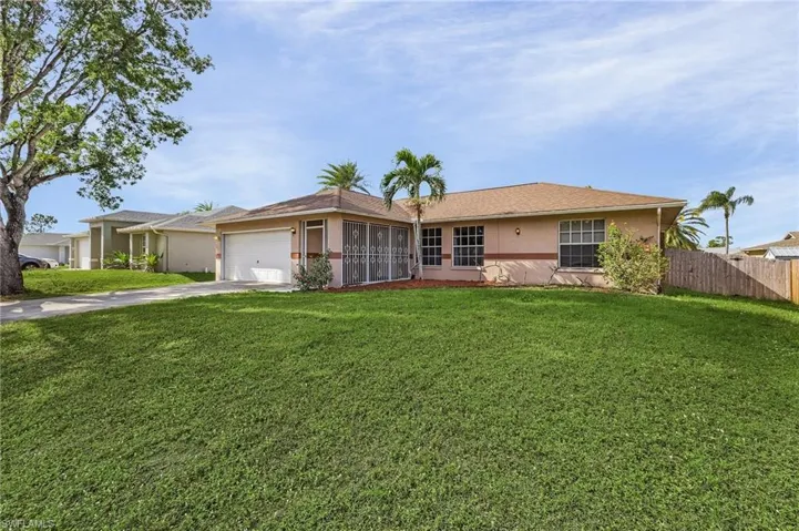 Ranch-style home featuring a front lawn and a garage