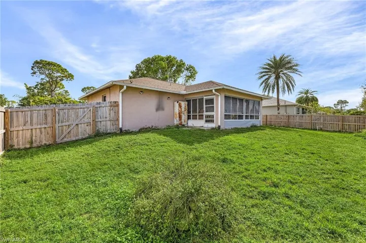 Back of house featuring a lawn and a sunroom