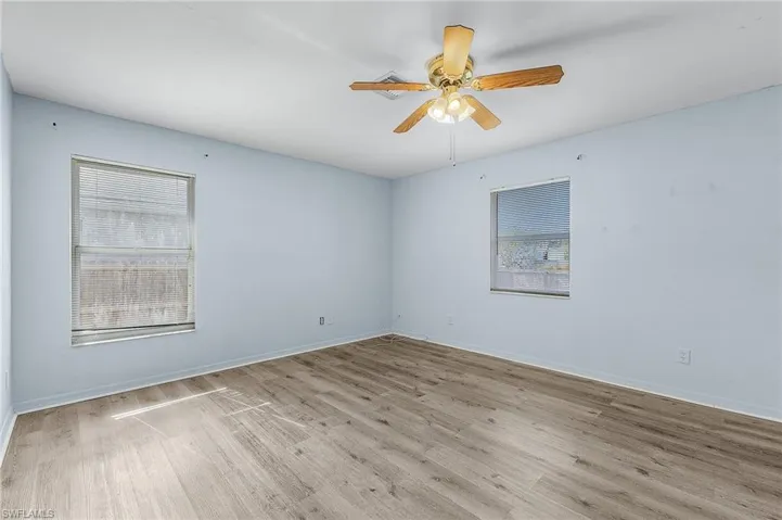Spare room with ceiling fan and light wood-type flooring