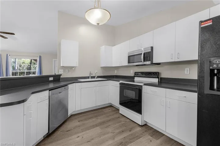 Kitchen with white cabinetry, sink, ceiling fan, and appliances with stainless steel finishes