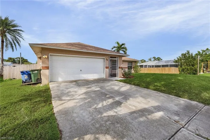 View of front of house featuring a garage and a front lawn