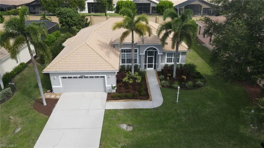 View of front of home featuring a tiled roof, stucco siding, concrete driveway, an attached garage, and a front yard