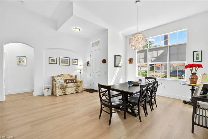 Dining area featuring light wood-type flooring and arched walkways