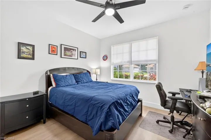 Bedroom with light wood finished floors, a ceiling fan, and a desk