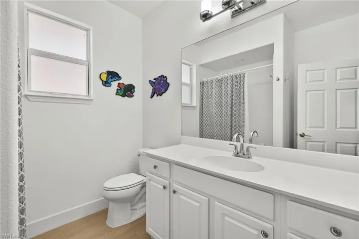 Guest Full bath featuring vanity, light wood-style floors, and curtained shower