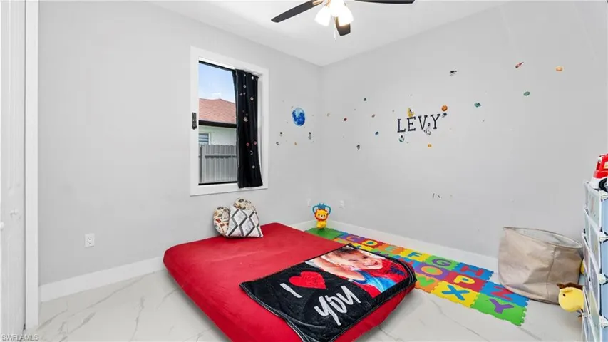 Bedroom with ceiling fan and light marble finish floors