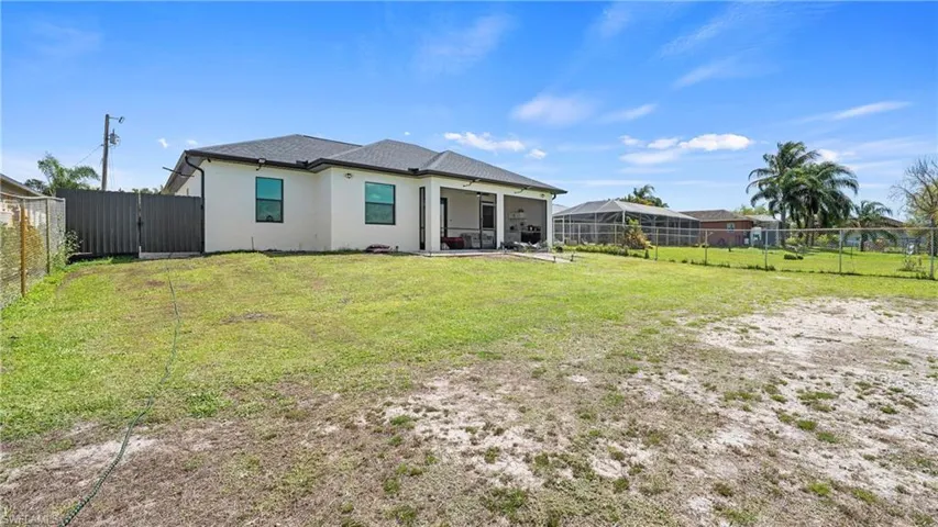 Back of house with stucco siding, a sunroom, a fenced backyard, ceiling fan, and a patio