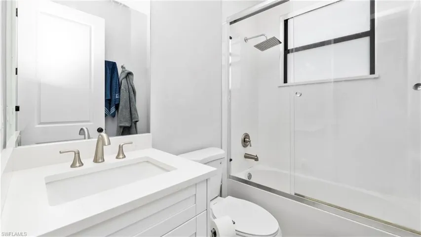 Full bath with vanity and combined bath / shower with glass door