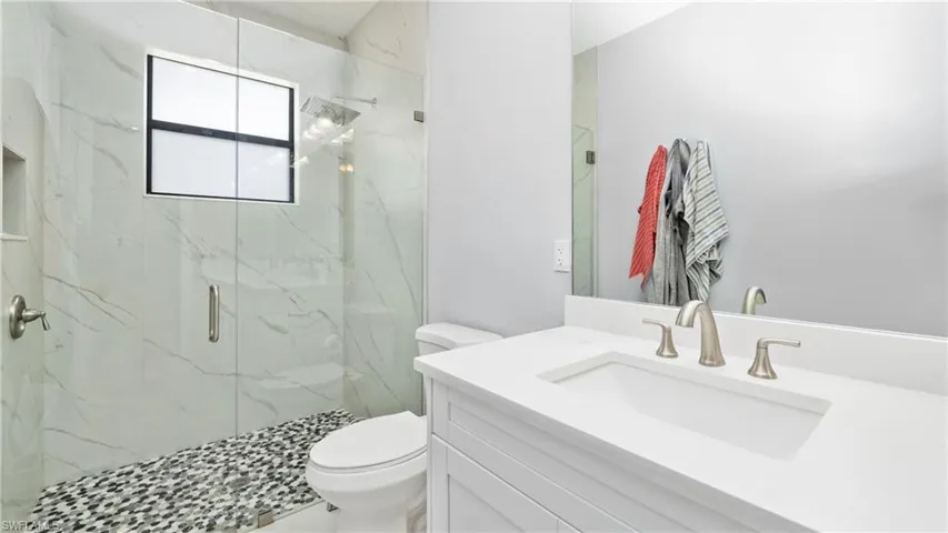 Full bathroom with vanity and a marble finish shower