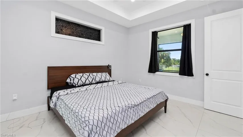 Bedroom with baseboards and light marble finish flooring