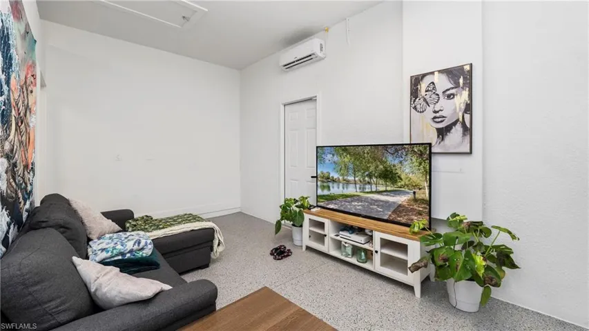 Living area with dark aggregate flooring and a mini split for heating / cooling