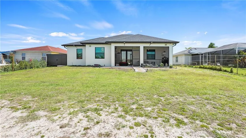 Rear view of property featuring a sunroom, a fenced backyard, and stucco siding