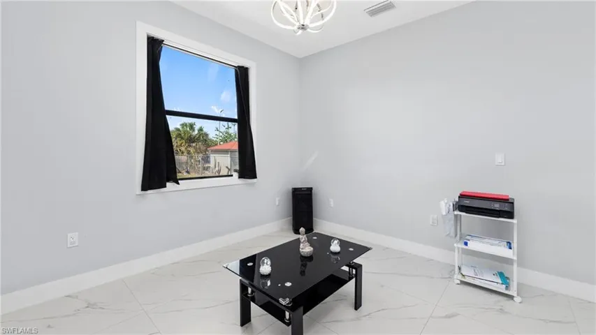 Living area featuring a chandelier and light marble finish floors