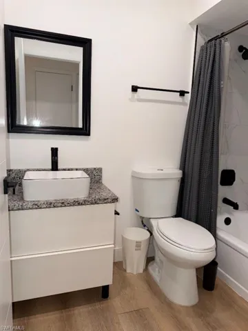 Modern bathroom featuring a white vanity with a rectangular vessel sink, granite countertop, and matte black faucet