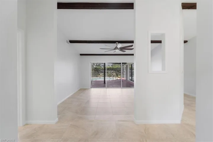 Hallway featuring baseboards and beamed ceiling