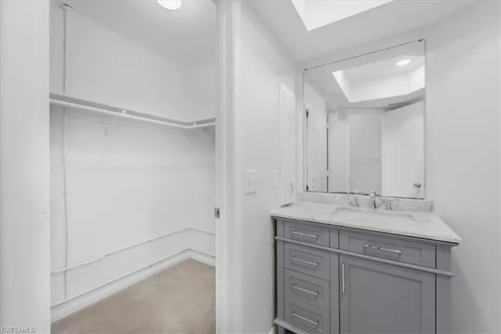 Bathroom featuring a walk in closet and vanity
