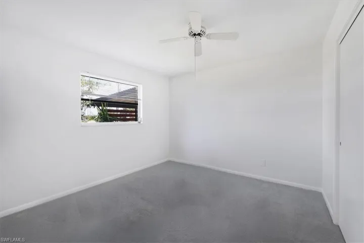 Carpeted spare room featuring baseboards and a ceiling fan