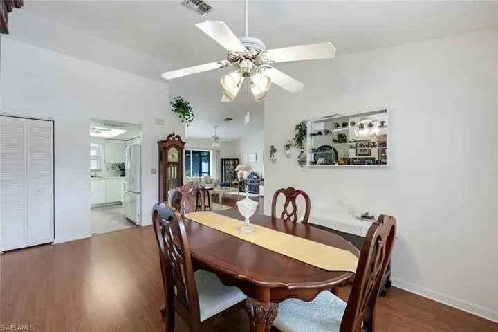 Dining area featuring visible vents, baseboards, ceiling fan, wood finished floors, and lofted ceiling