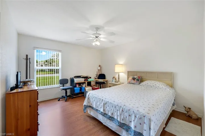 Bedroom featuring baseboards, ceiling fan, and wood finished floors