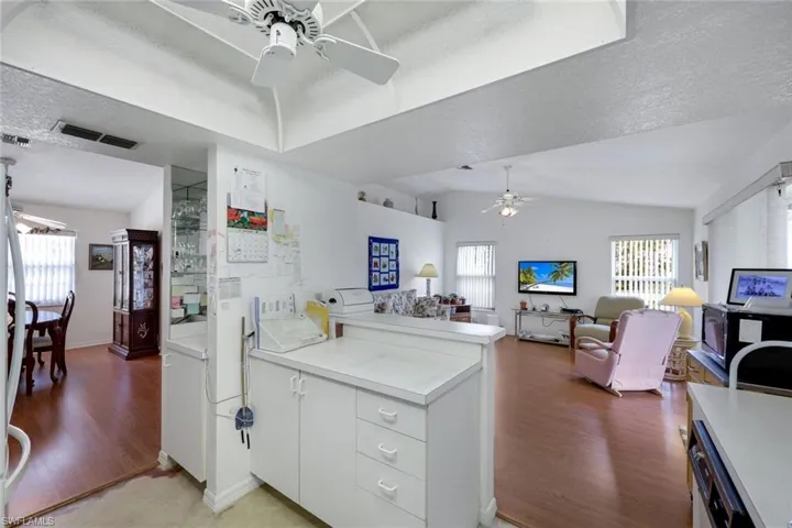 Kitchen with a ceiling fan, a peninsula, plenty of natural light, visible vents, and light wood-style floors