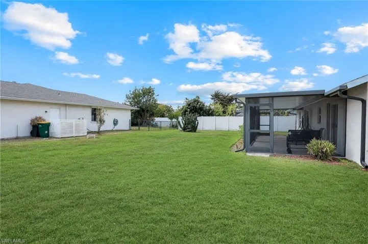 View of yard with a sunroom and fence
