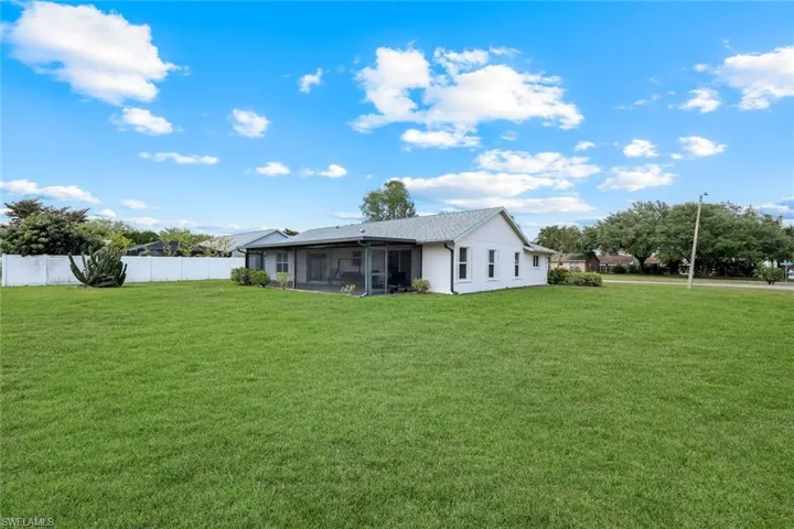 View of yard featuring a sunroom and fence