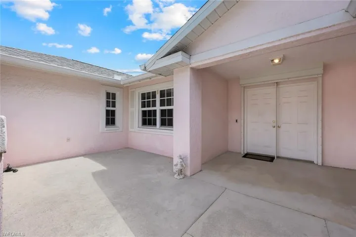 Property entrance featuring stucco siding and a patio area